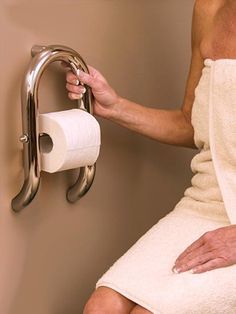 a man in a white robe is holding a roll of toilet paper on the wall