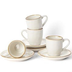 a set of four cups and saucers with gold rims