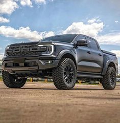 a gray truck parked on top of a dirt field