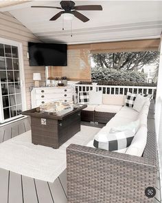 an outdoor living area with wicker furniture and a flat screen tv mounted on the wall