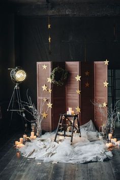 a room filled with lots of candles next to wooden shutters and stars on the wall