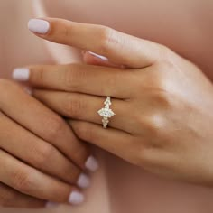 a woman's hand with a ring on her finger and a diamond in the middle