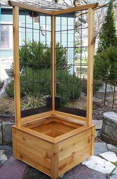 a wooden planter sitting on top of a stone walkway