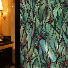 a bathroom with a large stained glass window next to a sink and mirror on the wall