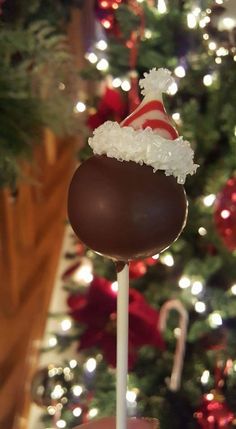 there is a chocolate candy on a stick in front of a christmas tree