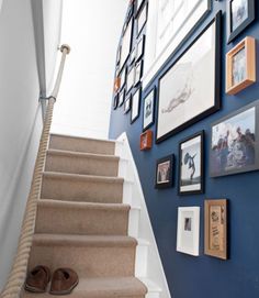 the stairs are lined with pictures and framed photos on the wall above them is a pair of slippers