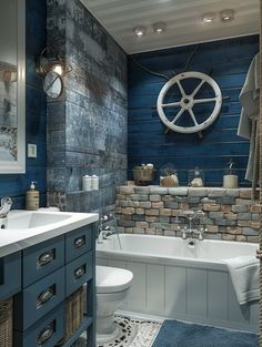 a bathroom with blue and white walls, a ship wheel hanging on the wall above the bathtub