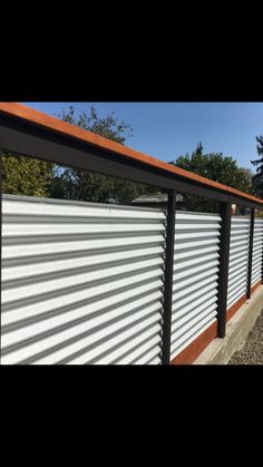 the side of a building with metal slats on it and trees in the background