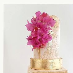 a three tiered cake with pink flowers on top