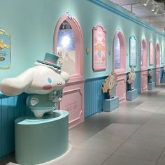 the interior of a children's playroom with pink and blue walls, arched windows, and cartoon characters