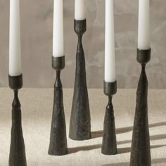 five candles are lined up in the shape of cones with white candlesticks sticking out of them