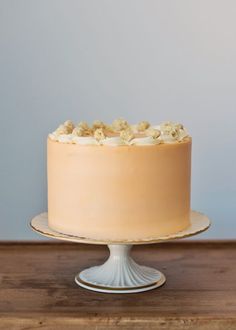 a frosted cake sitting on top of a wooden table