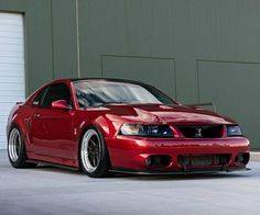 a red sports car parked in front of a garage