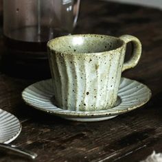 a coffee cup and saucer on a wooden table