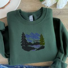 This Scenic Mountain Embroidered Sweatshirt is made to order.  Great gift!  Thread colors may need to change, depending on choice of sweatshirt color.  I will send a mockup after purchase. First three photos and thumbnail are mockups to show a different color option with design. If you need a 3XL or 4XL, send me a message and I will see what I can do with color and style. Hoodie Art, Custom Crewneck, Soft Gift, Autumn Fits, Thread Colors, Embroidered Sweatshirt, Embroidered Sweatshirts, Cute Gifts, Unisex Hoodies