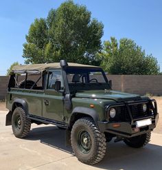 an army green truck parked in a parking lot