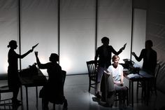 people standing and sitting around a table in the dark