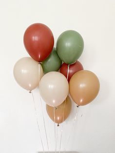 a bunch of balloons floating in the air on top of a cake with white frosting