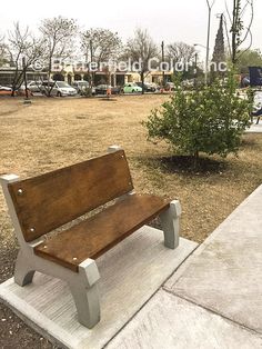 a wooden bench sitting on top of a cement slab