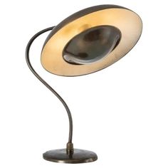 a table lamp that is on top of a metal base and has a light in the middle