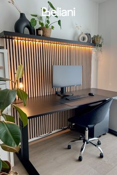 a desk with a computer on it and some potted plants in front of it