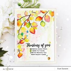 a card with watercolor leaves and the words thinking of you