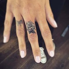 a woman's hand with a rose tattoo on it