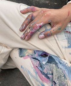 a woman with painted hands sitting on the ground