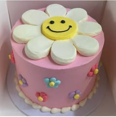 a pink and white cake with a smiley face on top