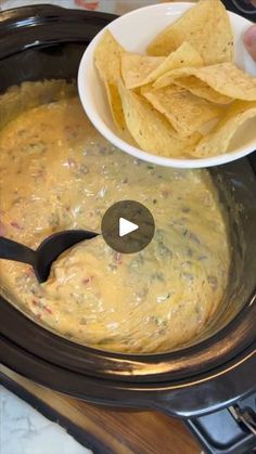 a bowl filled with tortilla chips on top of an electric stove next to a spoon