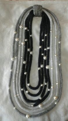 three stranded necklace with pearls and silver beads on white fabric, ready to be worn