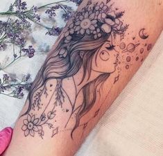 a woman's arm with flowers on it and a flower in her hair, next to some lavenders