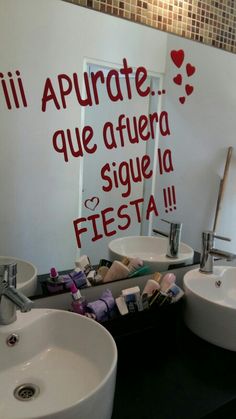 a bathroom with two sinks and a sign on the wall that says, i'll apurate que afuera sique la fiesta fiesta fiesta fiesta fiesta fiesta fiesta