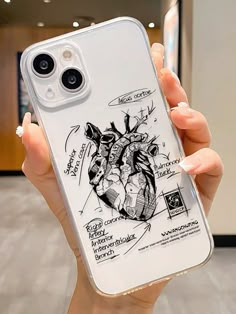 a woman holding up a phone case with an image of a heart and other things on it