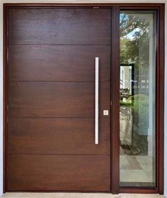 a modern wooden door with glass and metal handle on the front entrance to a house