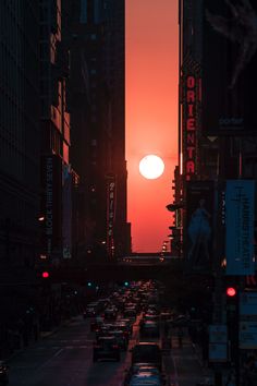 the sun is setting over a busy city street