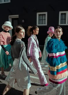 models walk down the runway in colorful outfits