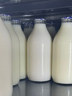 milk bottles are lined up on the shelf