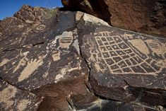 some rocks with drawings on them in the desert