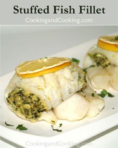 stuffed fish fillets on a white plate with lemon wedges