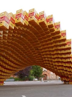 a very large wooden structure with many boxes on it's sides and some trees in the background