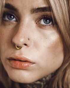 a close up of a woman with a nose piercing