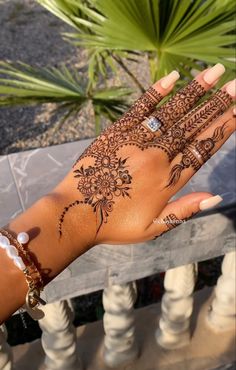 a woman's hand with henna tattoos on it