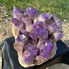 a cluster of purple crystals sitting on top of a rock