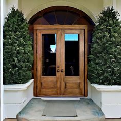 two wooden doors sitting next to each other on top of a stone step in front of a building