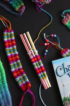 the book is laying next to some colorful crocheted beads and other items on a table