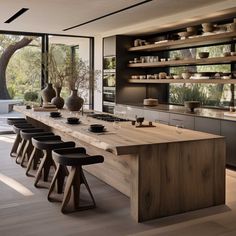 a large kitchen with wooden counter tops and stools next to an island in the middle