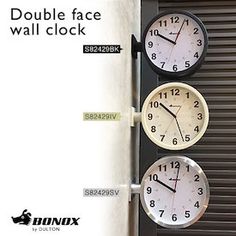 three clocks are hanging on the side of a building with words above them that read double face wall clock