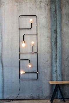 a light that is on the wall next to a table with a bench in front of it