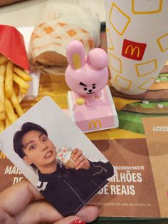 a person holding up a mcdonald's photo next to french fries